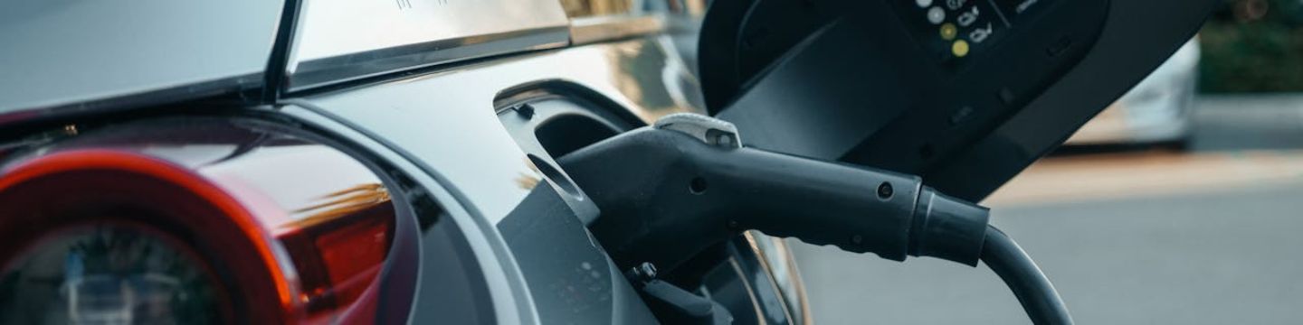 Auto ecologica in ricarica, con il cavo attaccato e un display che mostra l’avanzamento dell’energia accumulata. Auto ecologica in ricarica, con il cavo attaccato e un display che mostra l’avanzamento dell’energia accumulata.