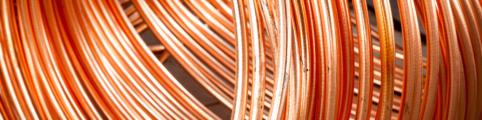 Fili di rame lucenti arrotolati: Primo piano di fili di rame brillanti e avvolti, pronti per l'uso in impianti elettrici.