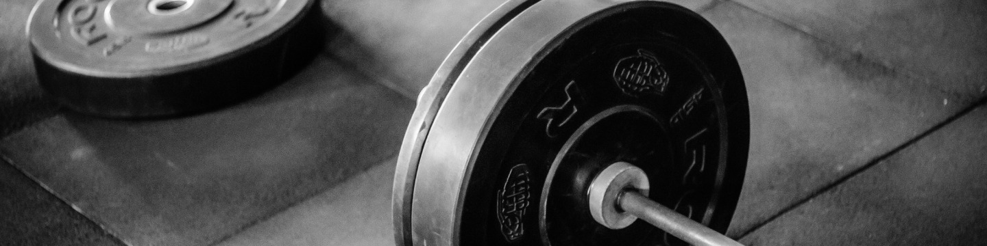 Sala pesi con persone che si allenano: Frequentatori di palestra impegnati in esercizi di forza e resistenza tra attrezzi e pesi