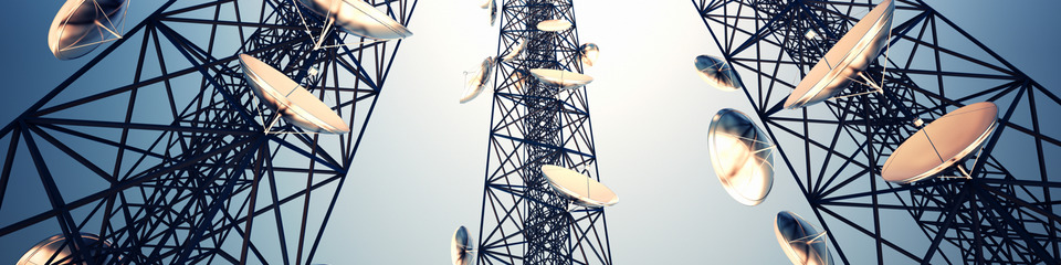 Diverse antenne di trasmissione installate su tralicci, con nuvole scure sullo sfondo.