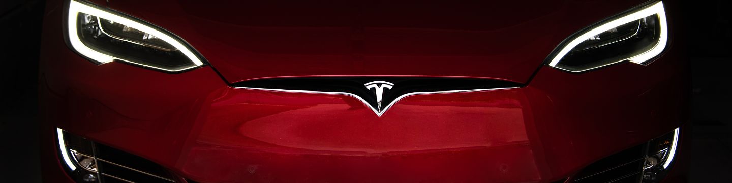 Un'auto Tesla scintillante parcheggiata sotto un cielo blu, pronta per una nuova avventura ecologica.