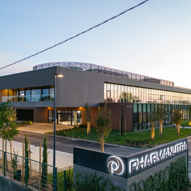 Vista dell’ingresso principale di Pharmanutra, con porte e logo visibili.