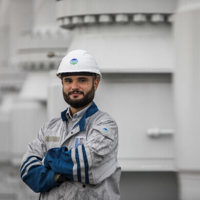 Dipendente Snam in uniforme aziendale, impegnato in attività operative e di controllo impianti.