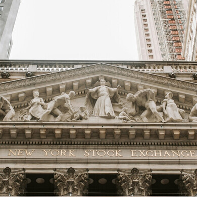 Facciata del New York Stock Exchange con colonne e bandiere, simbolo della borsa americana.