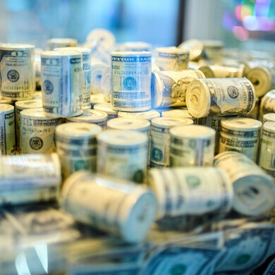 Pile di banconote USA arrotolate, simbolo di ricchezza, finanza ed economia