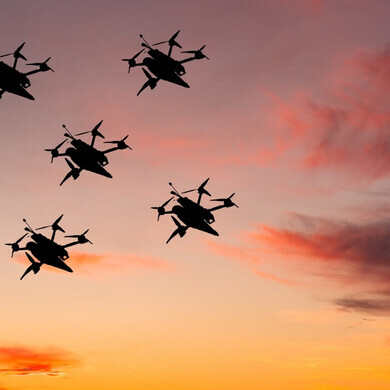 Numerosi droni autonomi, coordinati da intelligenza artificiale, volano in formazione nel cielo simulando un attacco kamikaze.