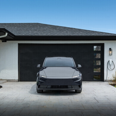 Immagine laterale di una Tesla Model Y Standard grigia, con dettagli della carrozzeria visibili.