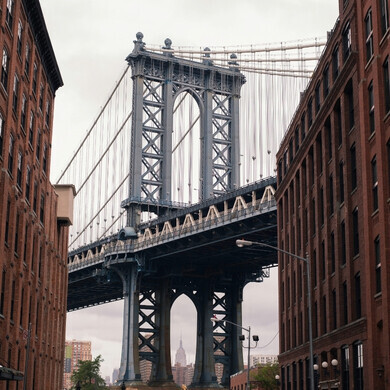 Inquadratura del Manhattan Bridge, con struttura metallica e vista della città sullo sfondo.