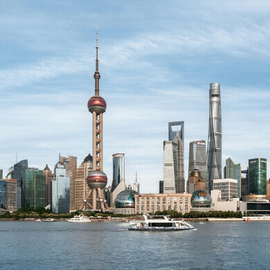 Shanghai di notte illuminata: Panorama notturno della città con edifici iconici illuminati e riflessi di luci colorate sul fiume