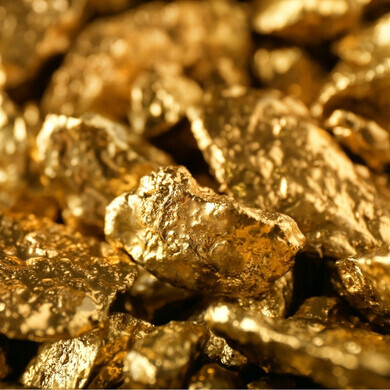 Pietre preziose e piccoli lingotti d’oro illuminati da luce calda