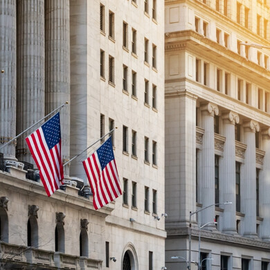 Strada principale di Wall Street con edifici storici e traffico urbano