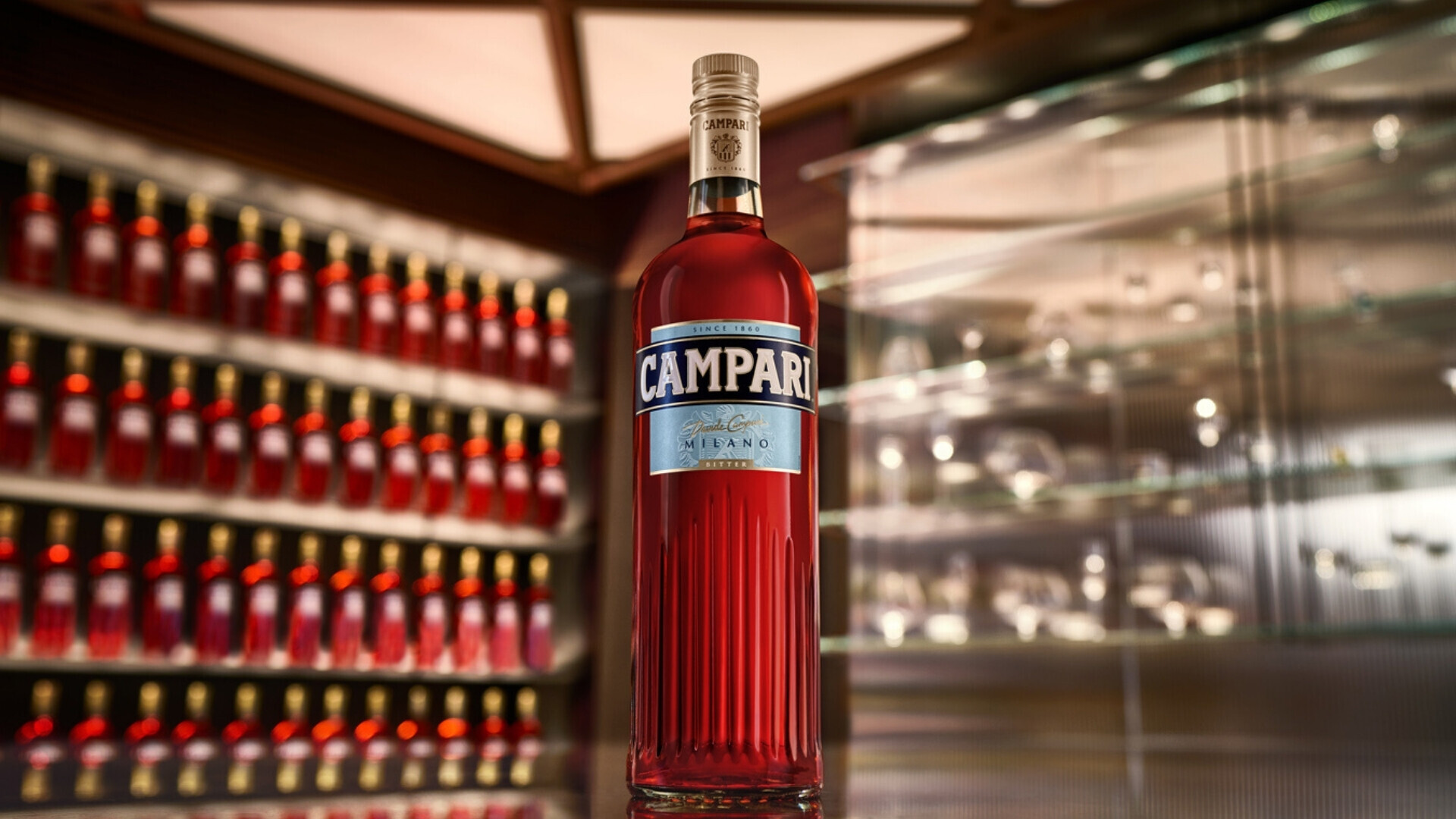 Immagine singola di una bottiglia Campari, protagonista assoluta grazie alla sua forma inconfondibile e al rosso brillante.