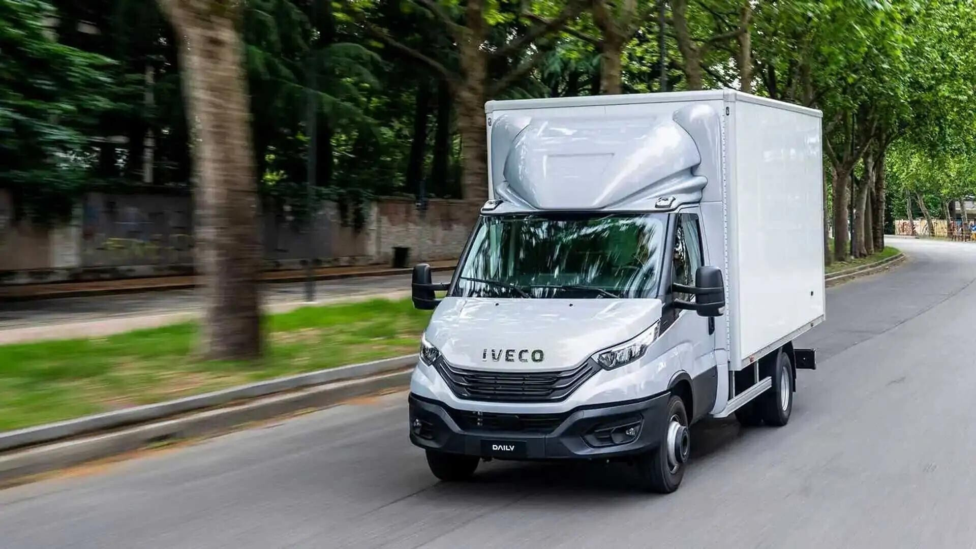 Camion Iveco bianco in movimento su strada.