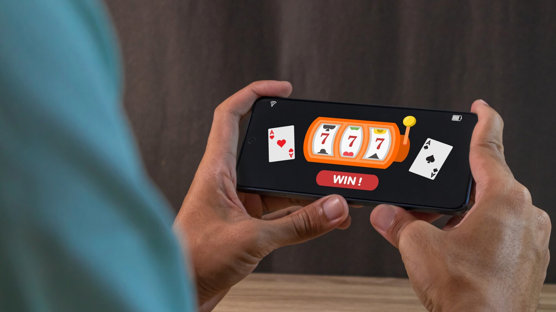 L'uomo vince il jackpot sull'app del casinò online su uno smartphone. Concetto di gioco d'azzardo nei casinò online. Uomo che vince il jackpot su un’app di casinò online usando lo smartphone. Concetto di gioco d’azzardo online.