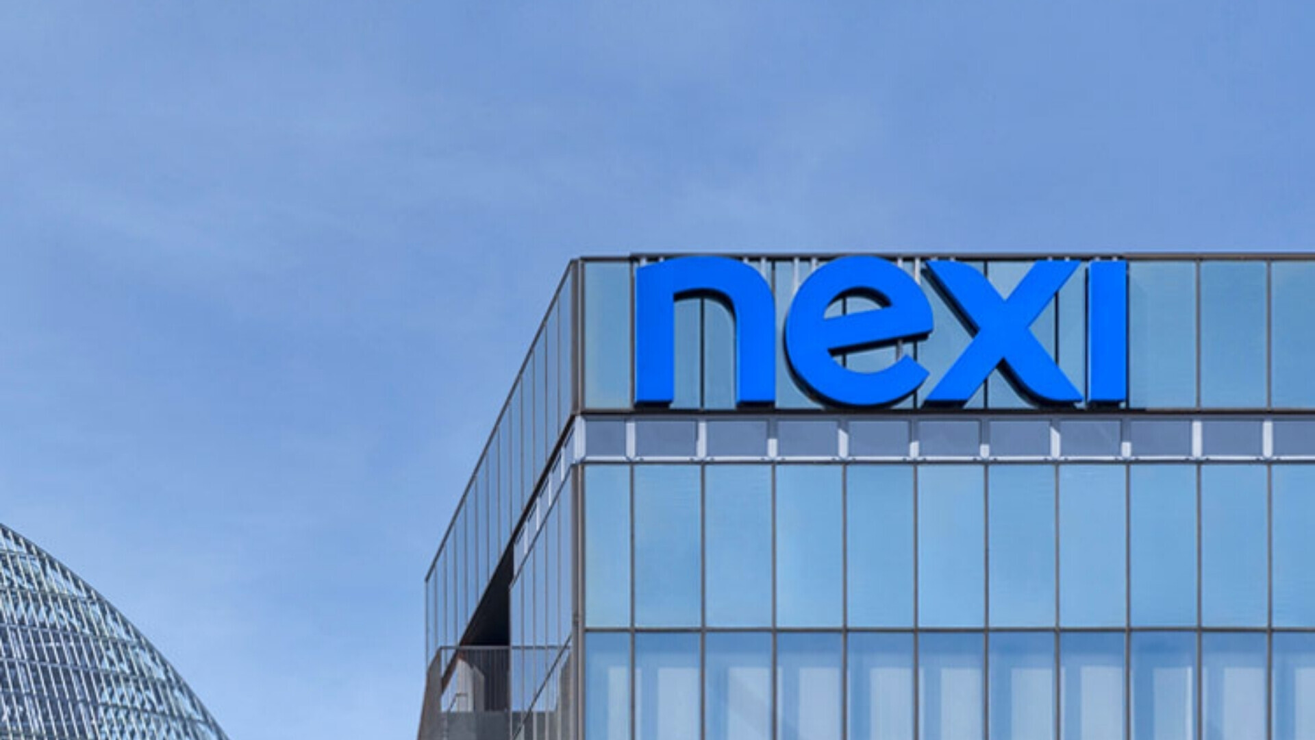 Vista esterna dell’edificio sede di Nexi, con logo visibile.