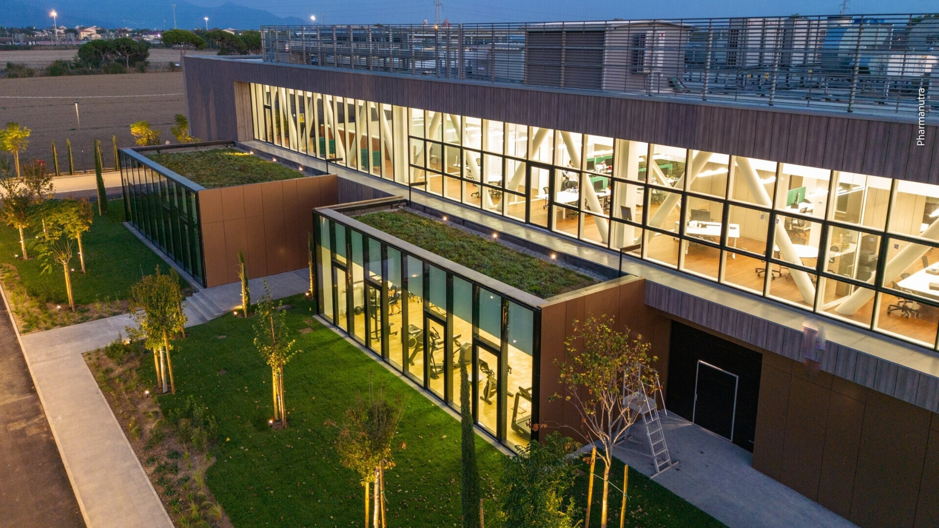 Vista notturna sede Pharmanutra Sede di Pharmanutra di notte, con luci accese e atmosfera serale.