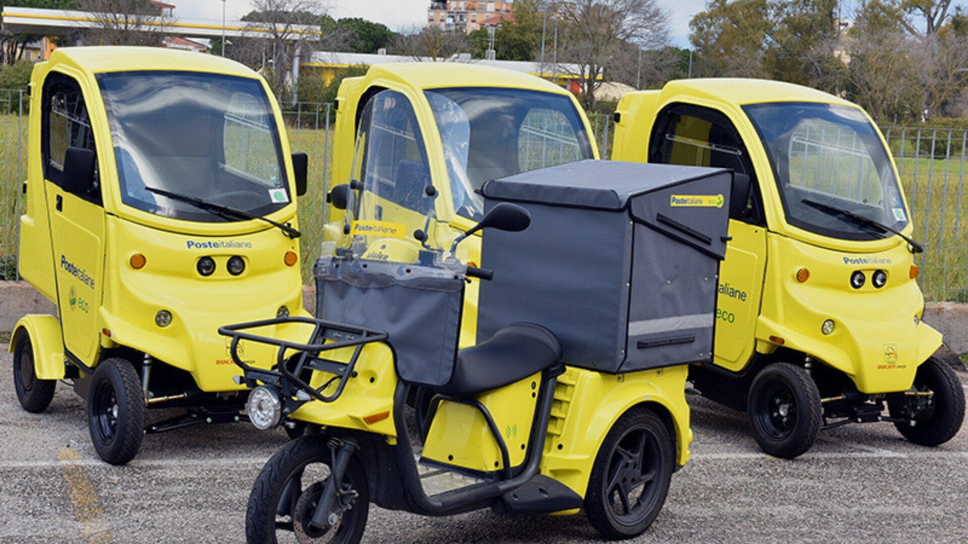 Veicoli della flotta aziendale Poste Italiane parcheggiati in area logistica, pronti per le operazioni di consegna.