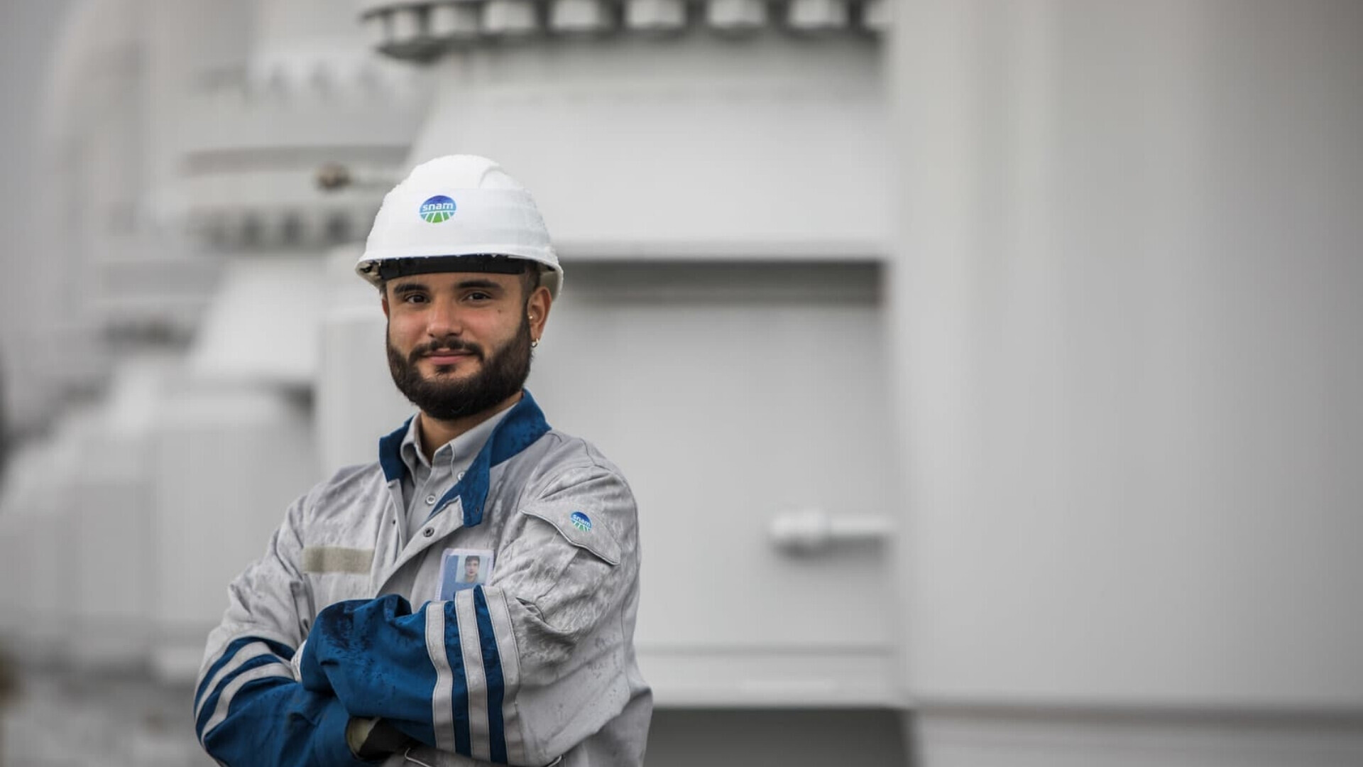 Dipendente Snam in uniforme aziendale, impegnato in attività operative e di controllo impianti.