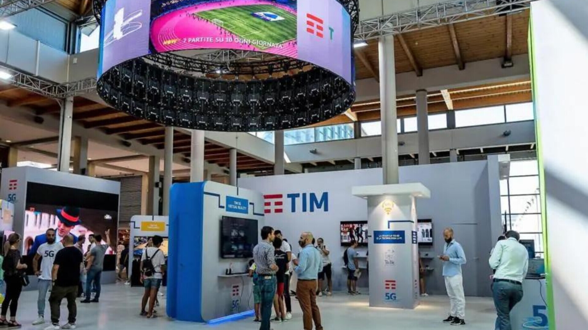 Stand promozionale TIM all’interno di un centro commerciale, con logo e materiali informativi visibili.