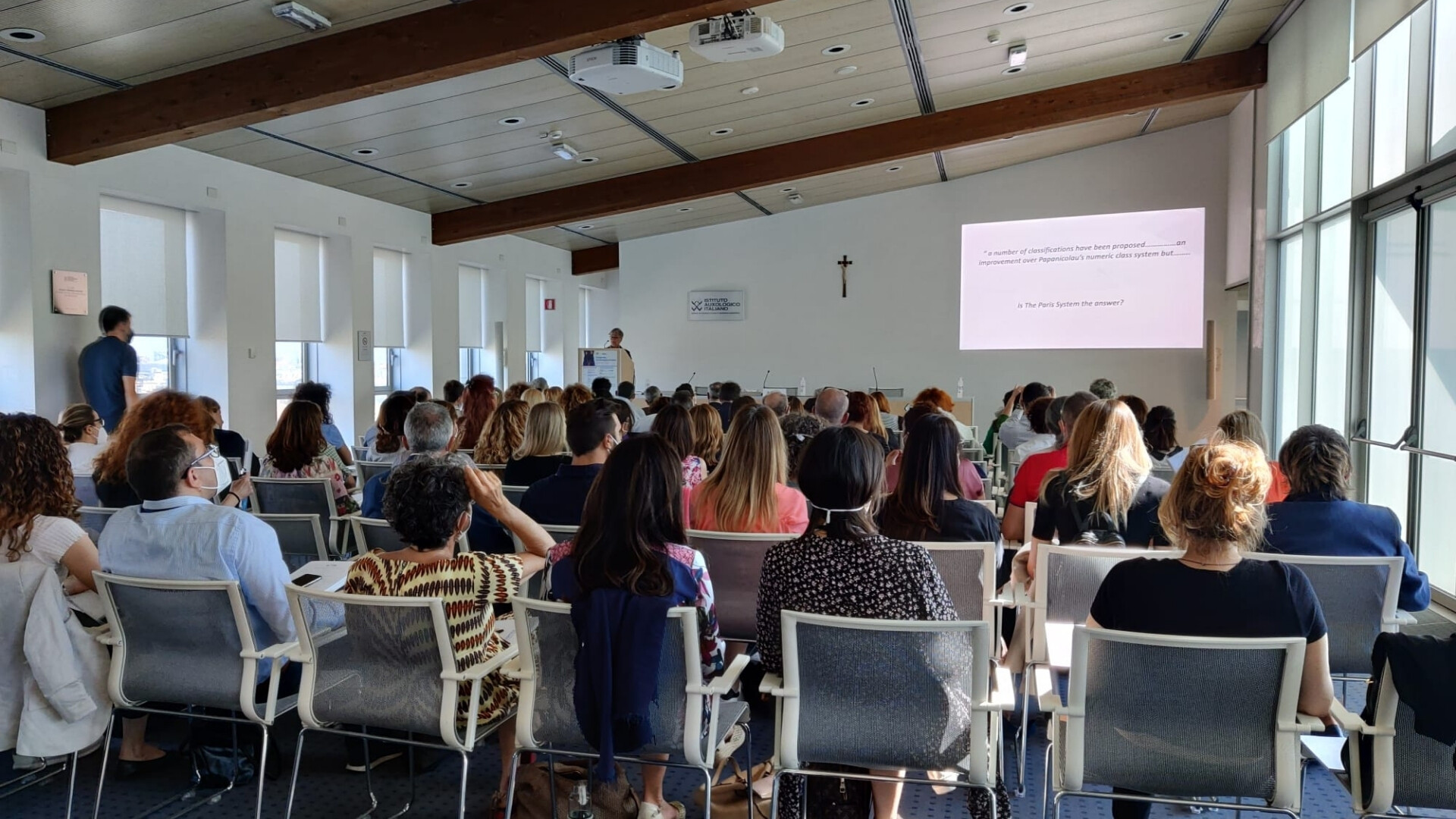 Evento o conferenza Ikonisys con relatori e pubblico in sala.