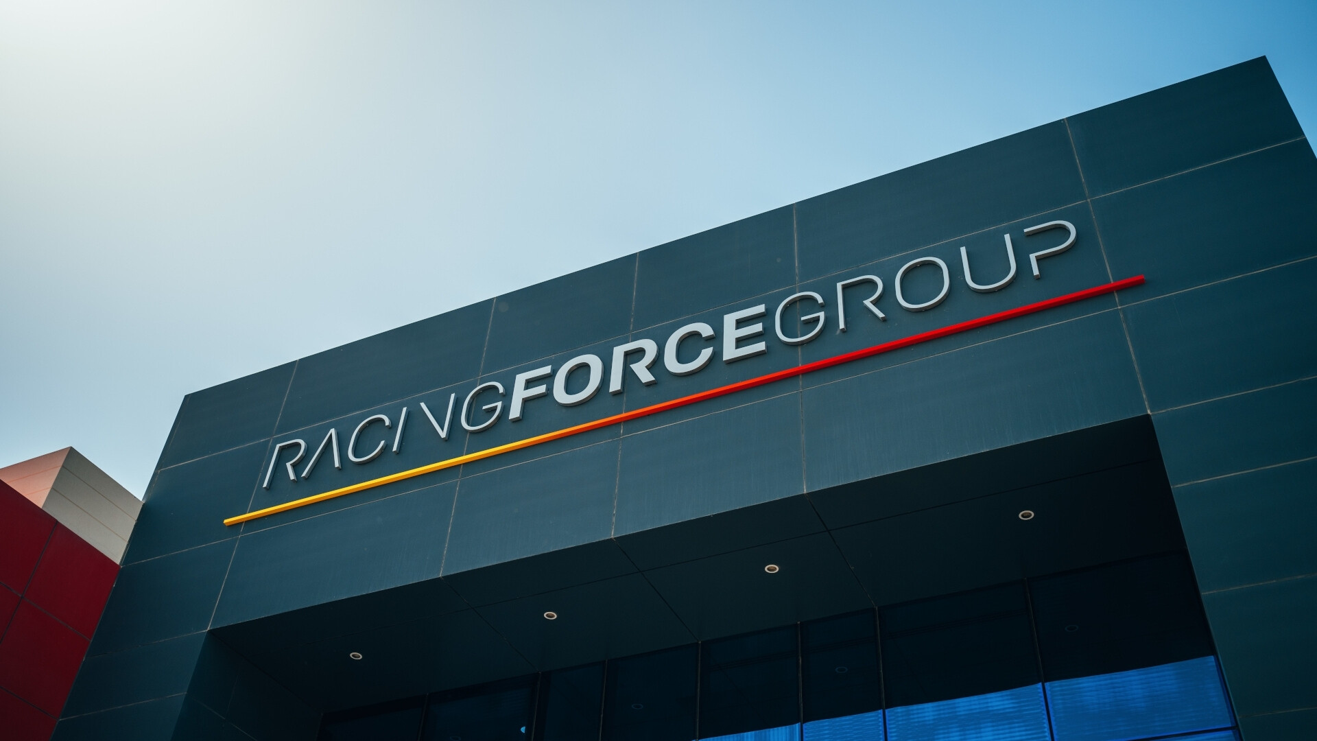 Ingresso sede Racing Force L’ingresso della sede Racing Force accoglie con modernità e spirito innovativo, cuore pulsante del motorsport.