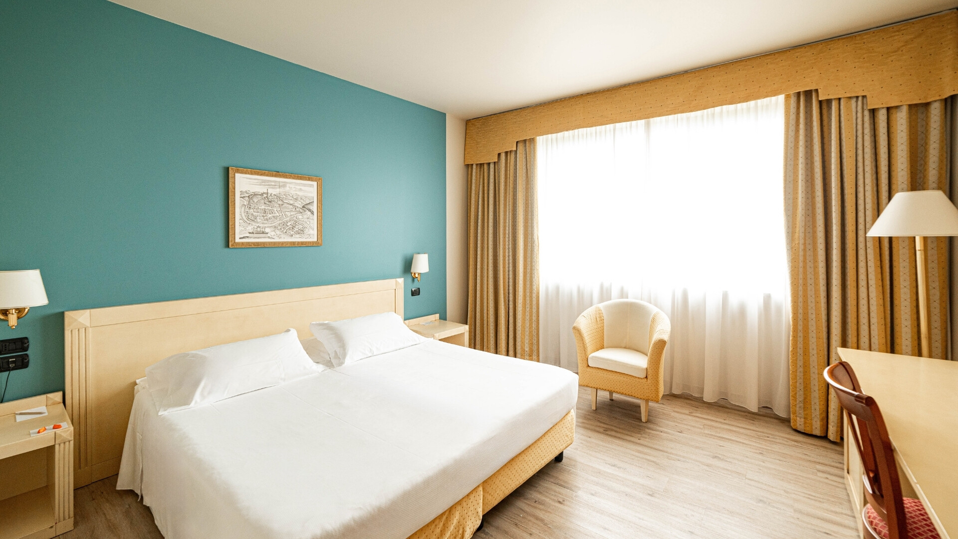 Camera da letto del Phi Hotel Xenia, spaziosa e confortevole con design raffinato.