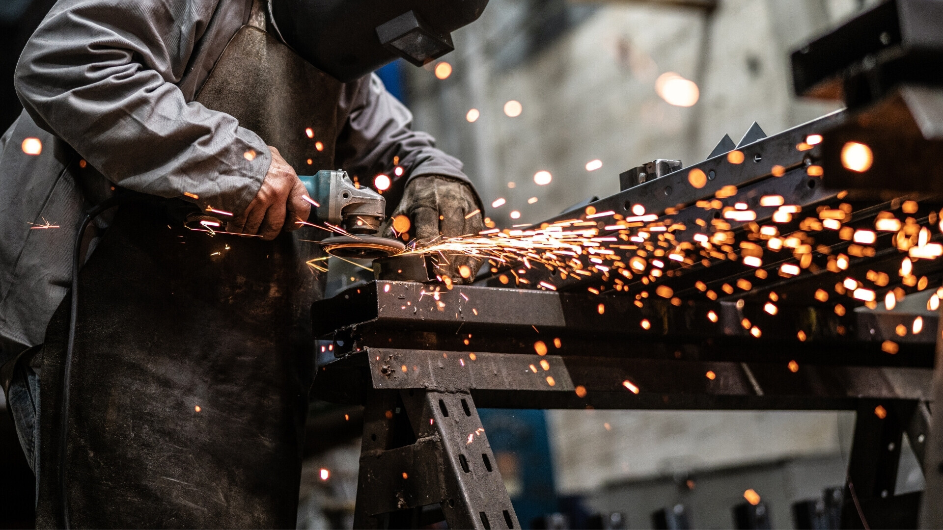 Operatore industriale impegnato nella lavorazione dell’acciaio con macchinari pesanti in ambiente produttivo