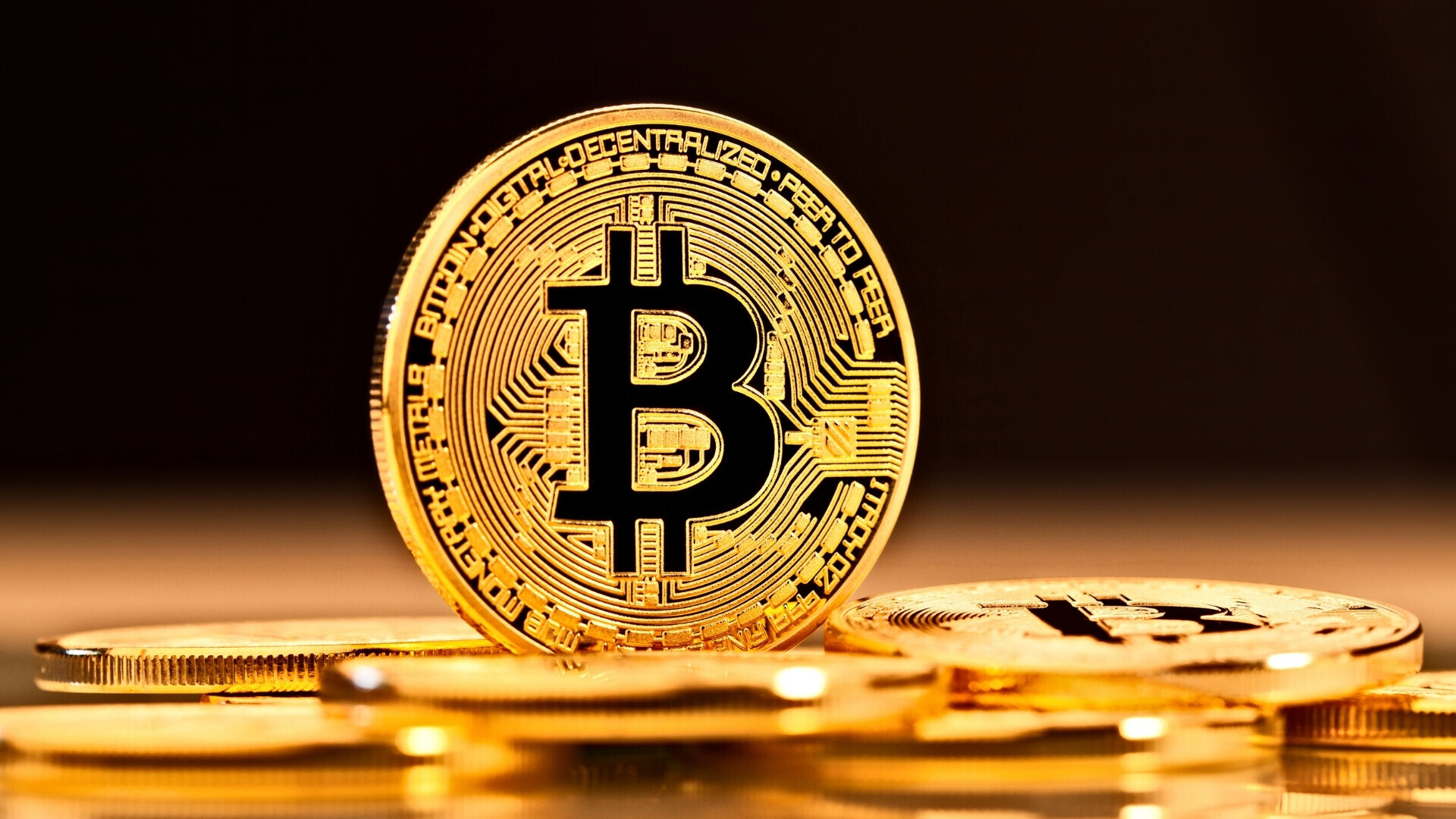 Moneta di bitcoin in primo piano nascosta per metà Bitcoin in primo piano parzialmente in ombra