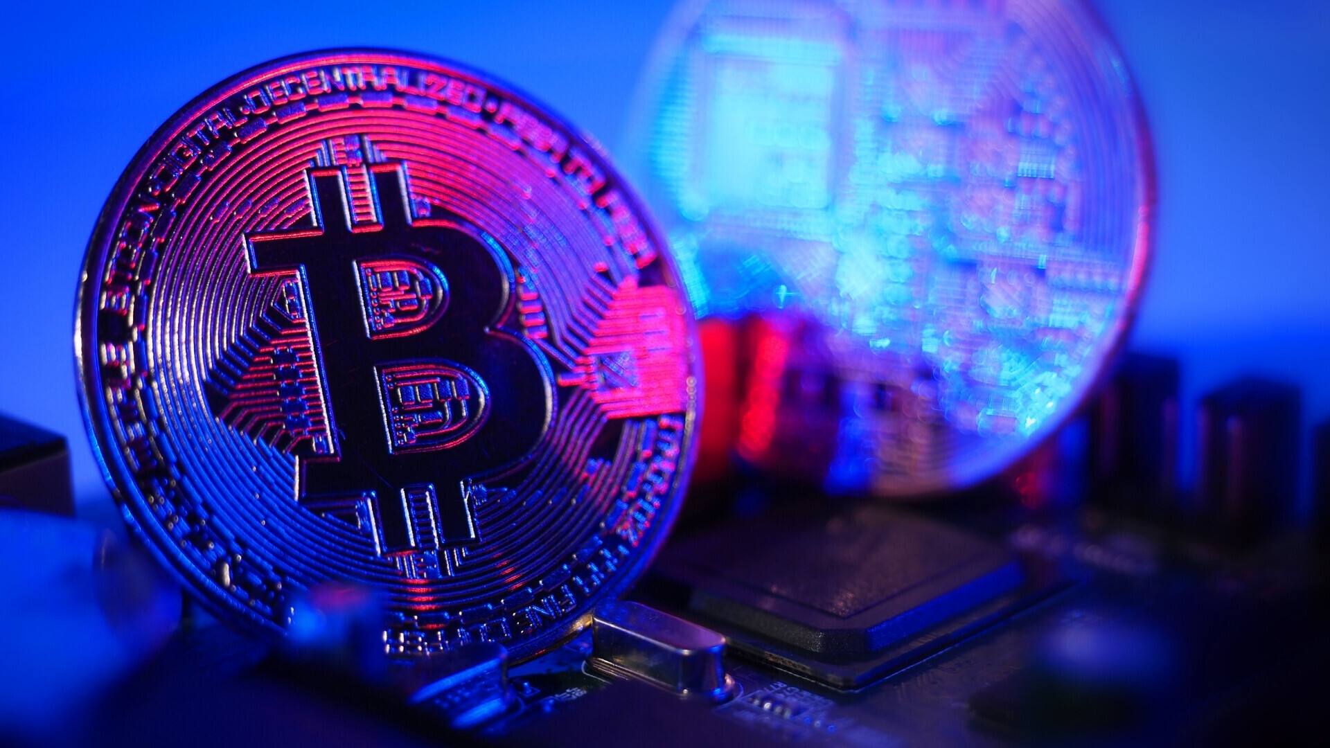 Moneta di bitcoin al buio con un bagliore di luce Bitcoin illuminato da un fascio di luce su sfondo scuro