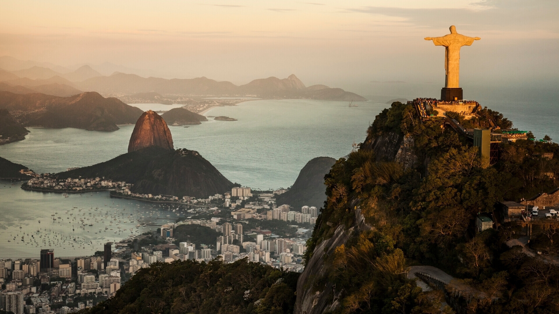 Vista di Rio de Janeiro al tramonto Panorama della città di Rio de Janeiro al tramonto, con il Cristo Redentore e le montagne illuminate dalla luce calda.