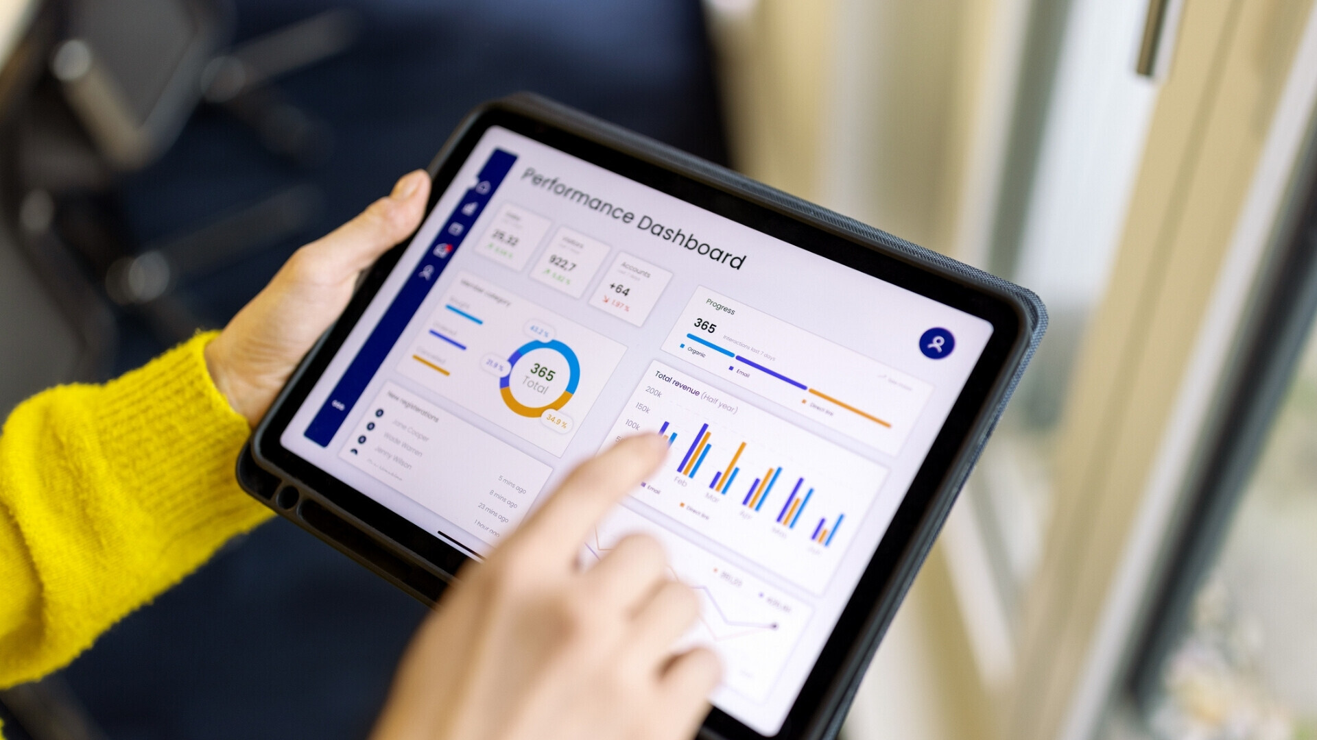 Professionista che esamina un report infografico su tablet in ufficio.