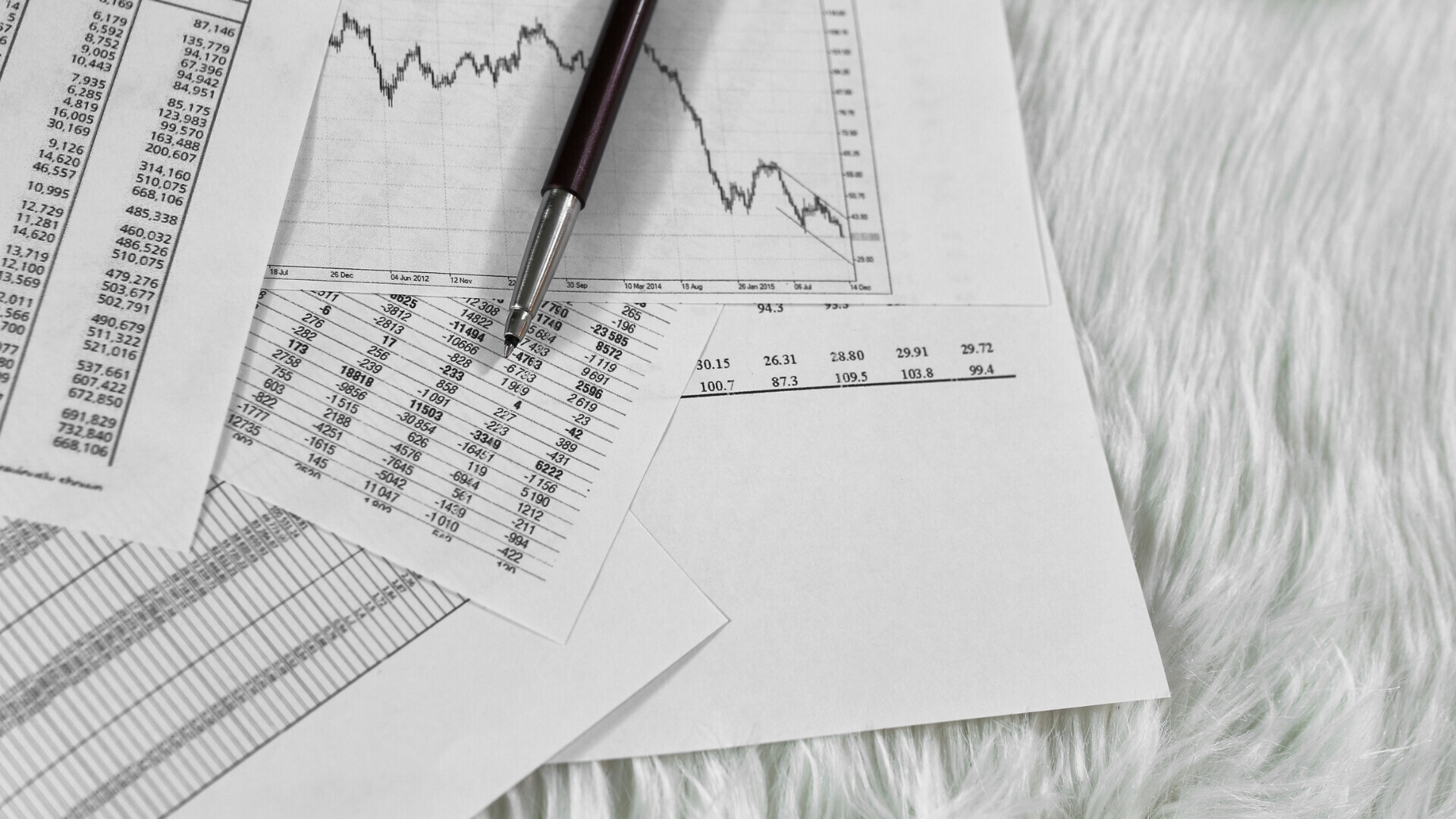 Schermo con dati e tabelle di conti finanziari, grafici e numeri per analisi economica.