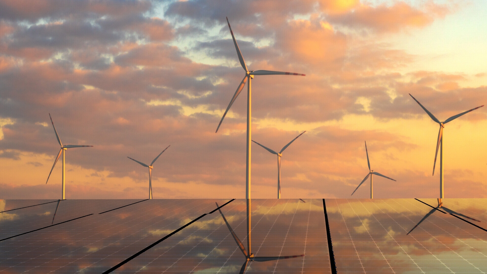 Pannelli solari e pale eoliche al tramonto Pale eoliche e pannelli solari fotografati al tramonto con cielo arancione e rosa