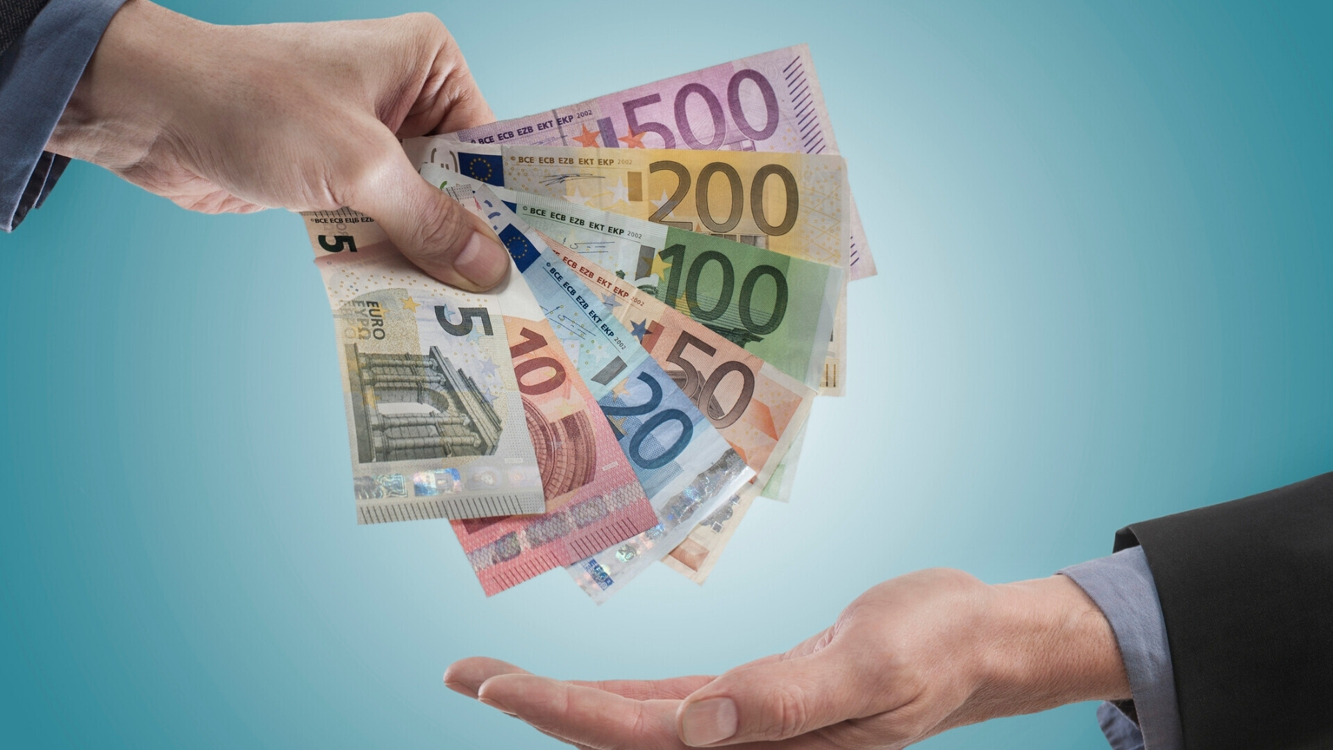 Imprenditore che paga il salario ai suoi dipendenti, Baviera, Germania Uomo d’affari che consegna buste paga ai lavoratori, in un contesto professionale di ufficio o azienda.