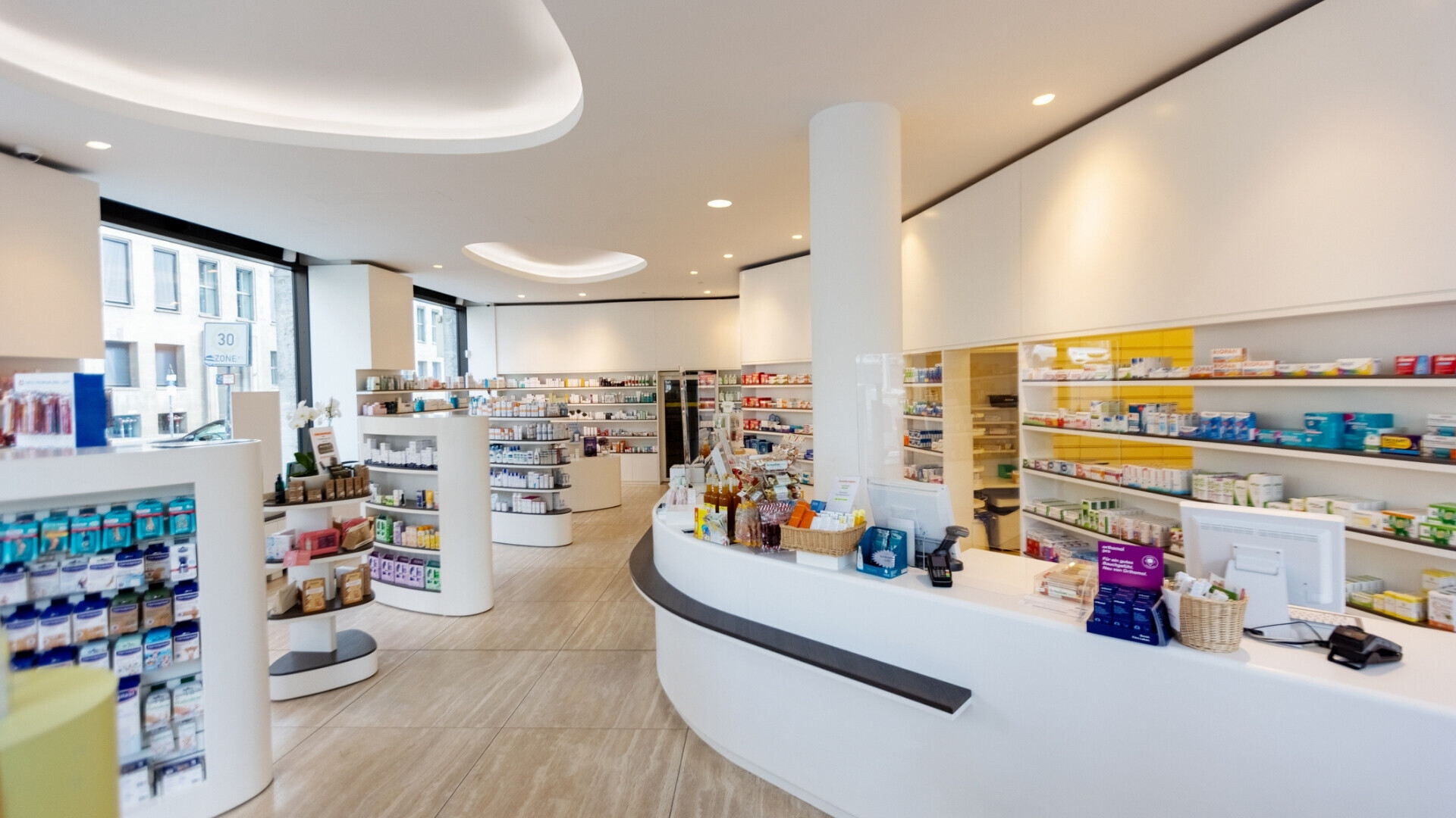 Interno moderno di una farmacia Interno di una farmacia moderna, con scaffali e ripiani pieni di medicinali, senza persone presenti.