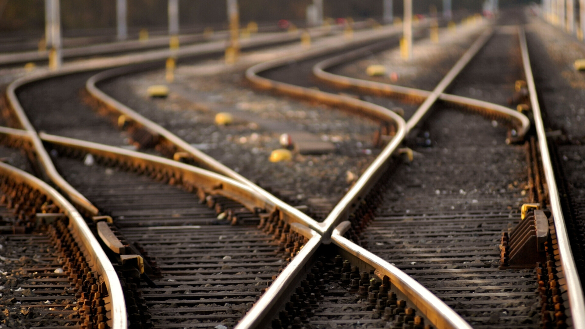 Due binari di ferro che si estendono verso l’orizzonte tra paesaggio urbano o rurale