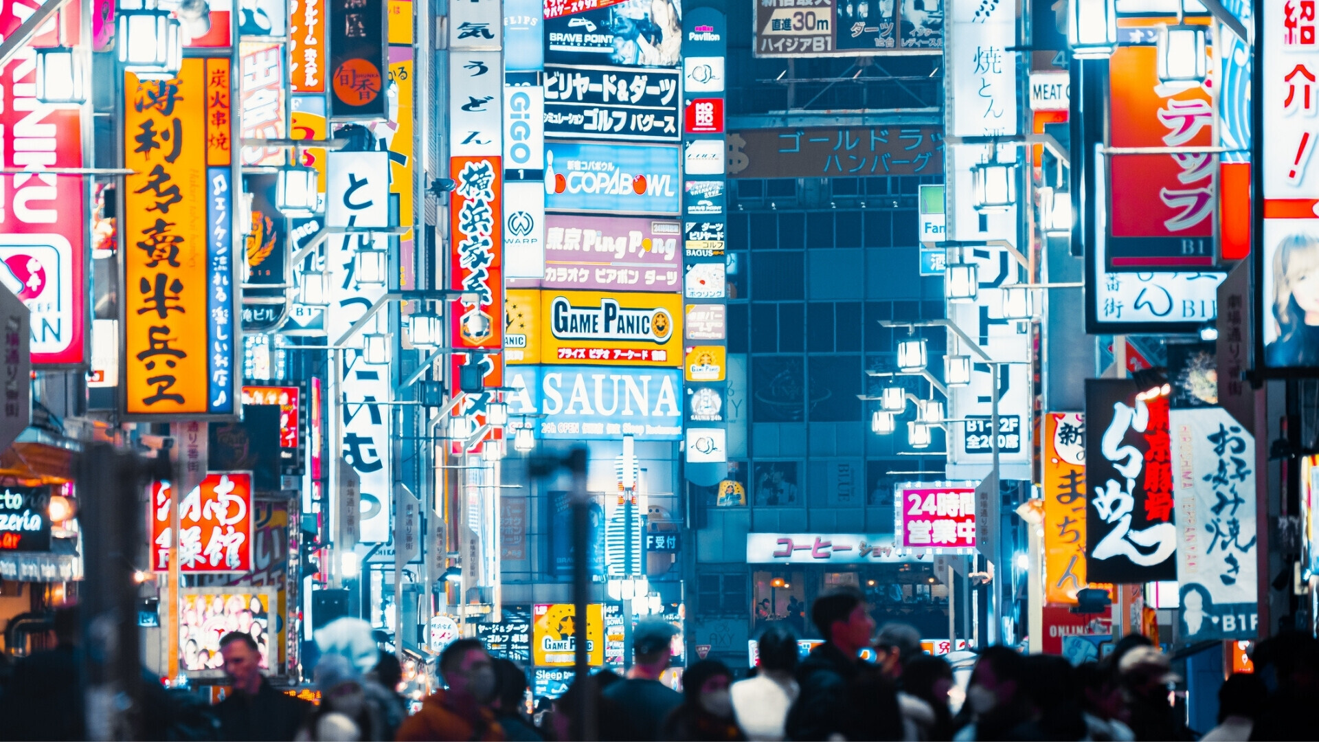 Persone che attraversano la strada di notte all’ingresso di Kabukicho a Tokyo.