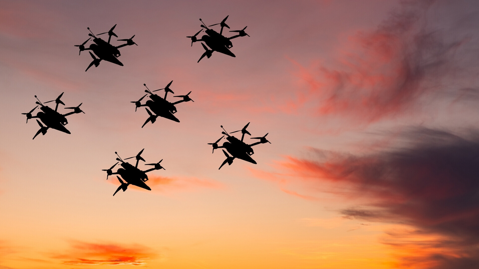 Numerosi droni autonomi, coordinati da intelligenza artificiale, volano in formazione nel cielo simulando un attacco kamikaze.