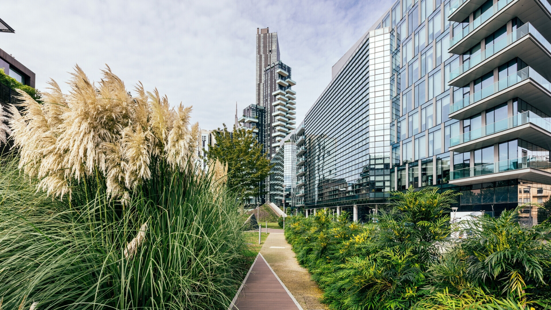 Edifici moderni del quartiere business di Porta Nuova a Milano, circondati da alberi e aree verdi