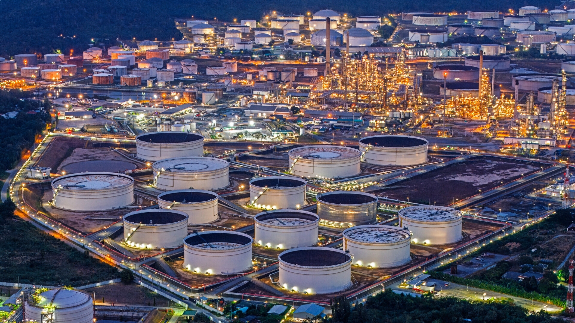 Vista aerea di una raffineria petrolchimica con serbatoi, tubazioni e impianti industriali, simbolo dell’industria energetica e della lavorazione del petrolio.