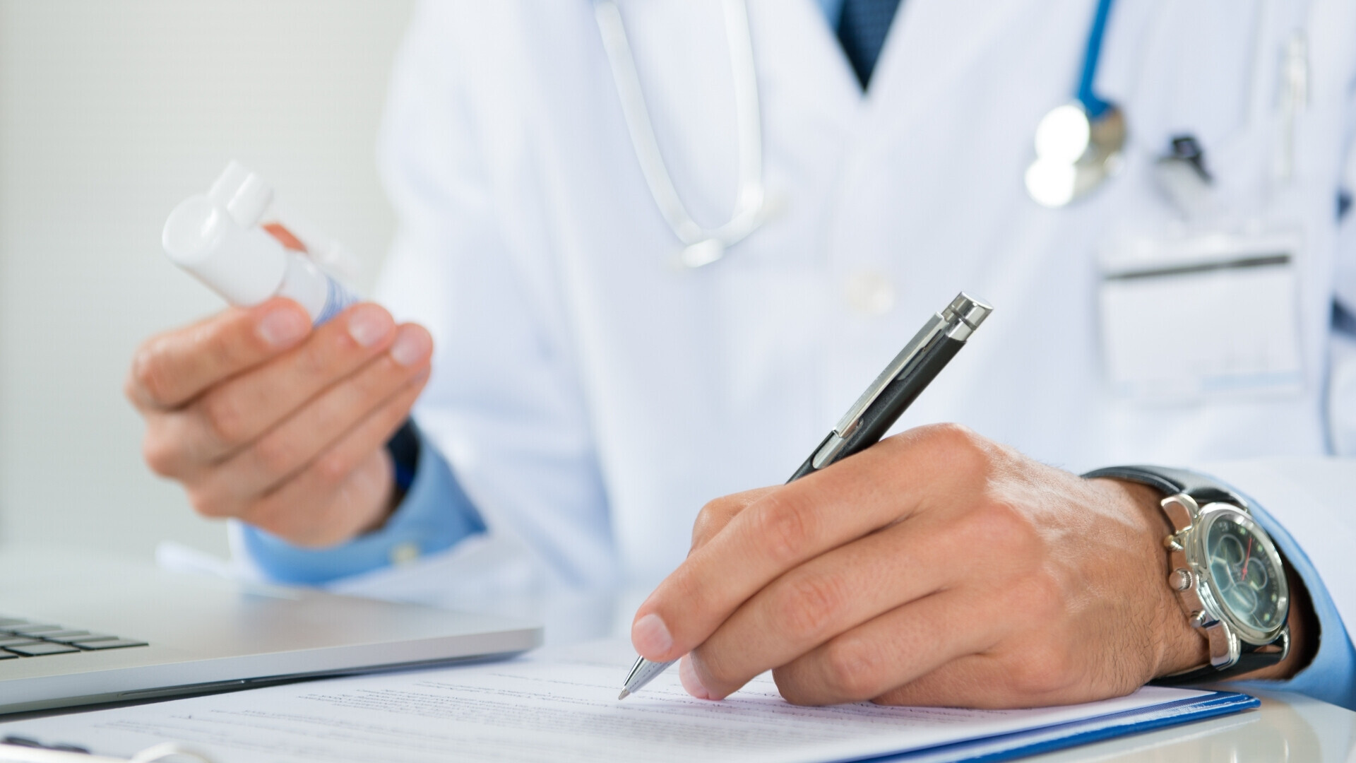 Dottore che compila una ricetta medica su un modulo clinico