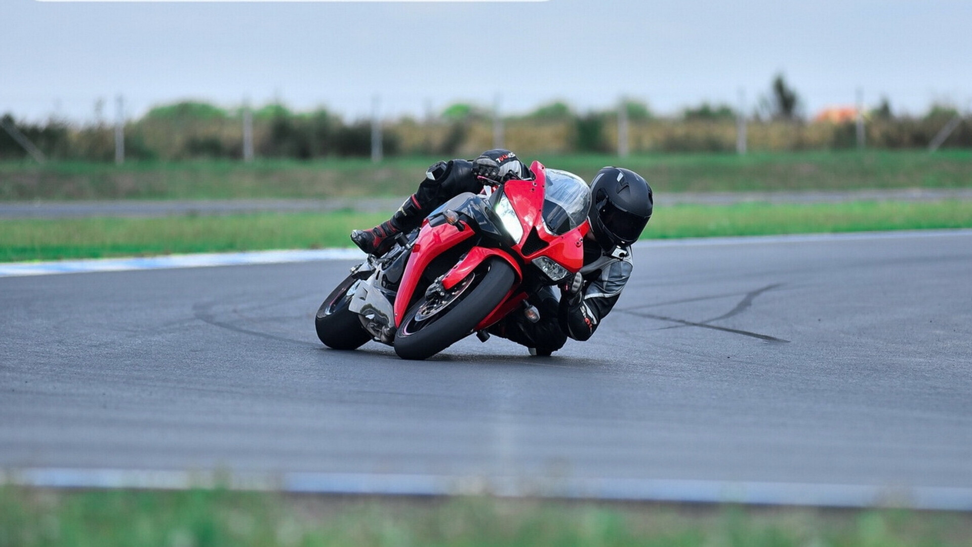 Motociclista in curva Pilota di moto in curva su pista da circuito