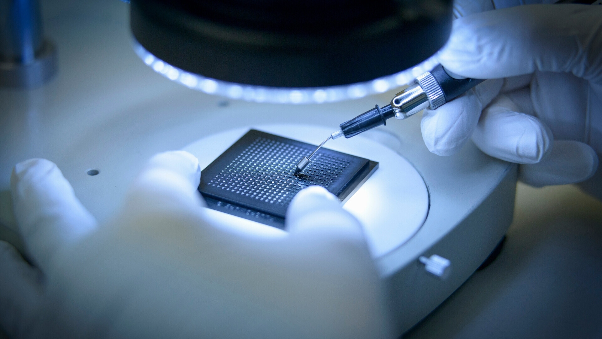 Tecnico elettronico che controlla piccoli chip elettronici in laboratorio a camera pulita, primo piano Operatore in tuta protettiva che esamina microchip con precisione, simbolo di tecnologia avanzata e ricerca elettronica.