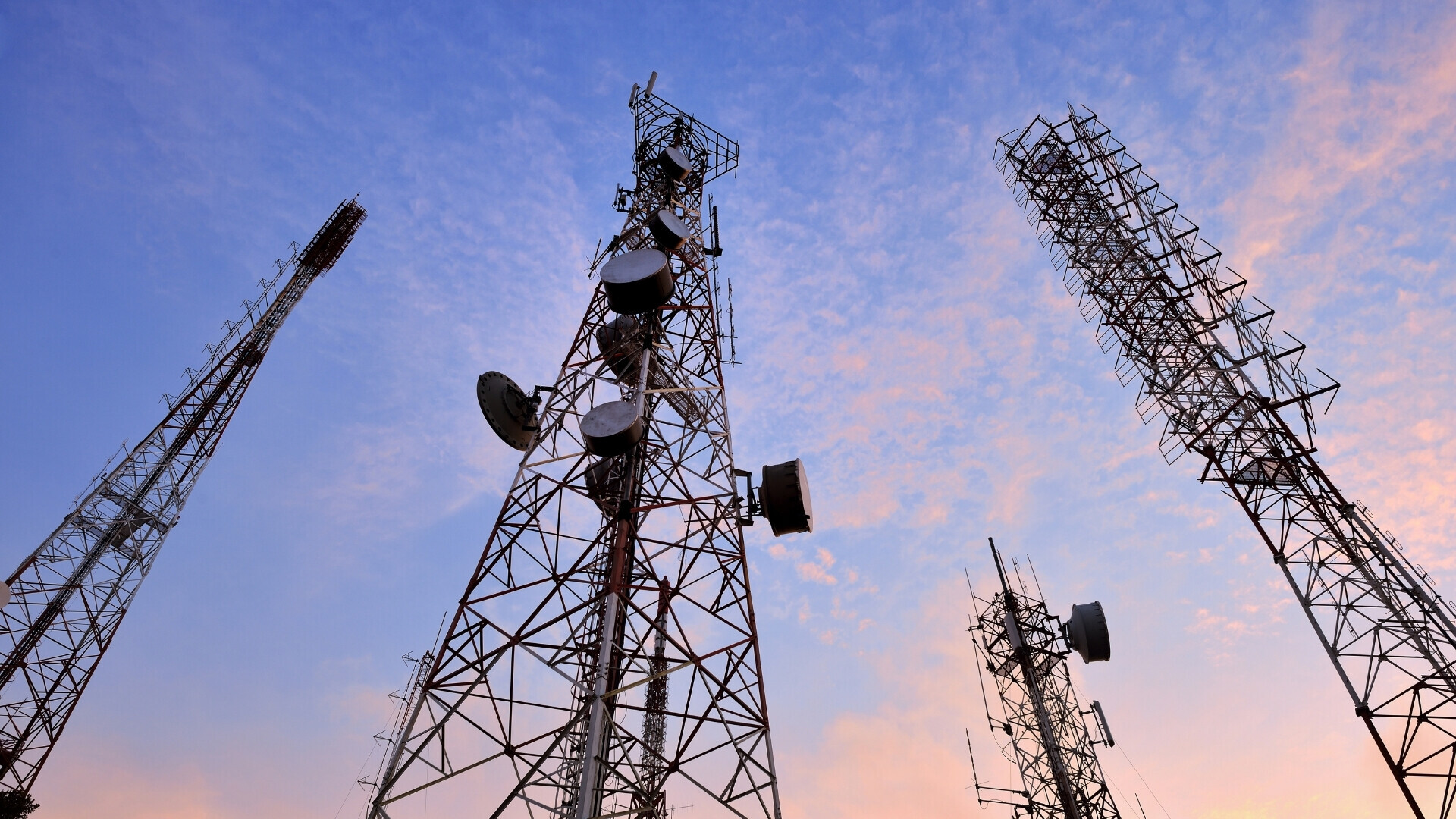 Fotografia di torri elettriche in acciaio con linee ad alta tensione visibili, su sfondo naturale o urbano.