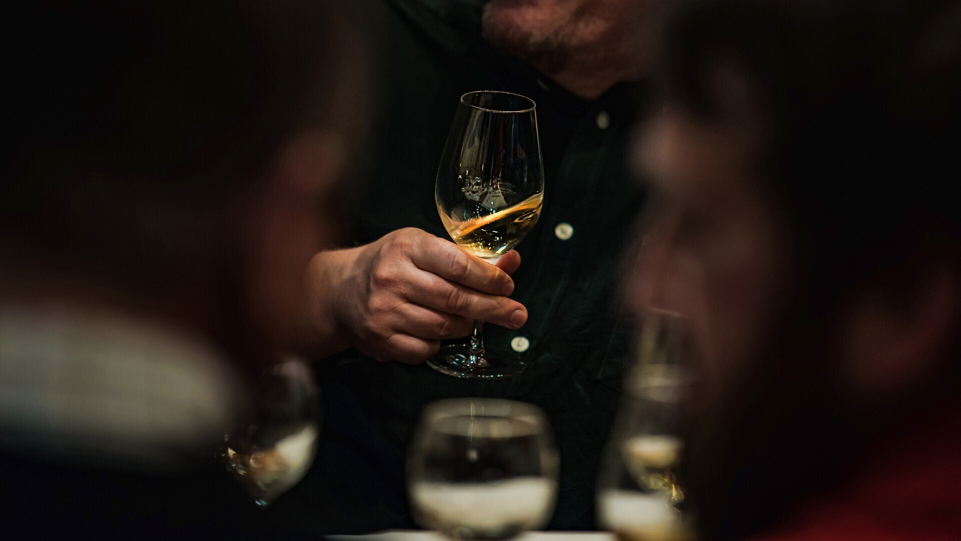 Calice di vino rosso su sfondo scuro Ripresa ravvicinata di un bicchiere di vino rosso illuminato da luce laterale.