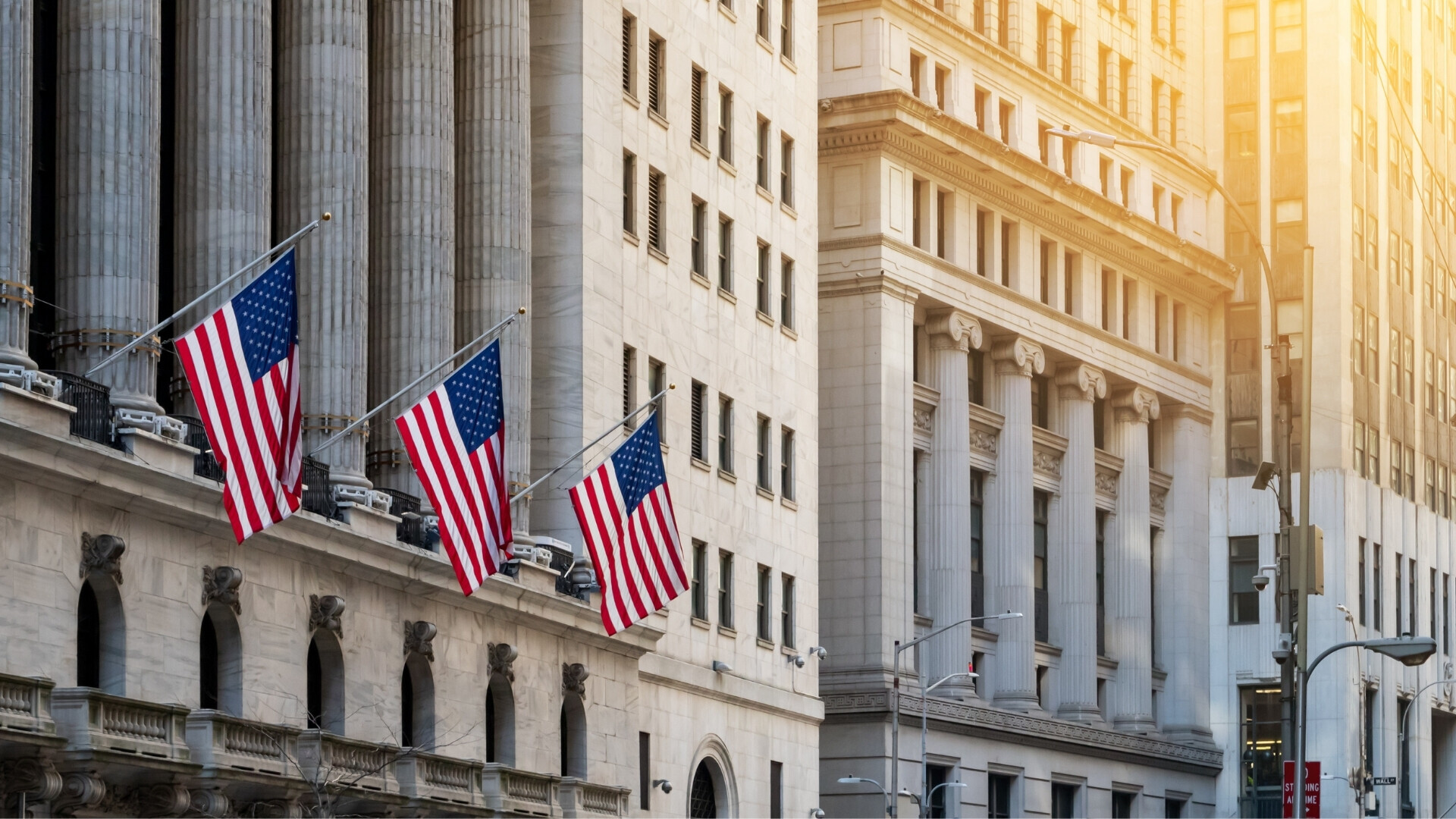 Strada principale di Wall Street con edifici storici e traffico urbano